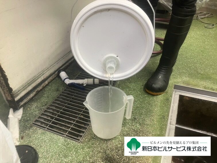 石鹸水化工法による清掃で、油脂を分解する専用薬剤をグリストラップ内に投入している写真