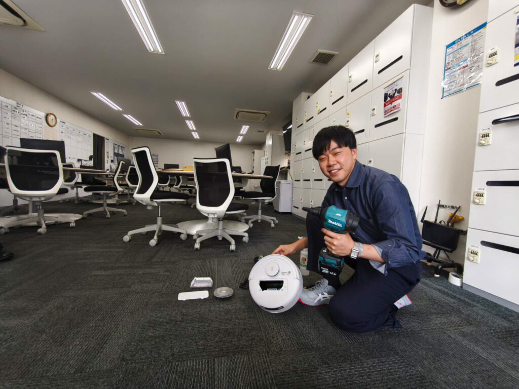 ロボット掃除機のメンテナンスを行うスタッフ