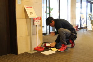宿泊施設の消防設備（消火器）の点検を行う様子